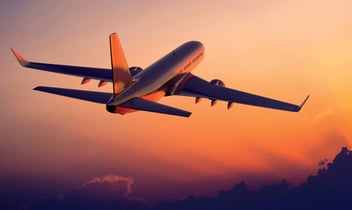 Airplane mid-flight as the sun sets